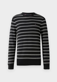 Maglione a righe bianche e nere con collo rotondo, maniche lunghe e polsini a costine, dotato di un piccolo logo sul petto.