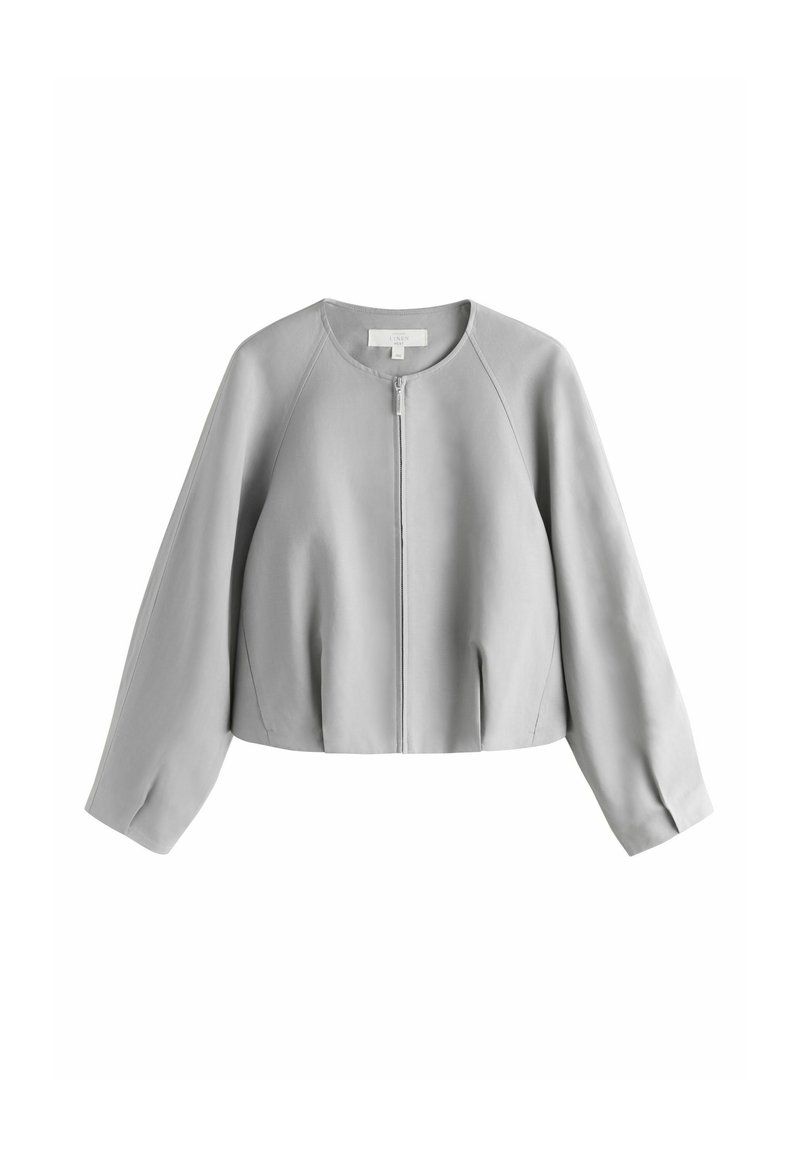 Jachetă gri scurtă din material moale. Are decolteu rotund, închidere frontală cu fermoar și mâneci largi, lungi, cu pliuri delicate.