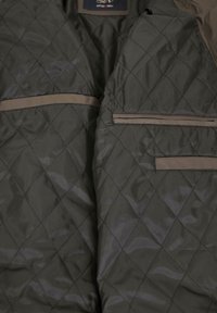 Vollständig gefütterte, dunkelgrüne Jacke mit diamantförmigem Muster und taupefarbenen Akzenten. Verfügt über zwei Fronttaschen mit Klappen. Glatte, glänzende Textur.