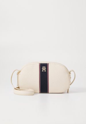 Petit sac bandoulière en cuir texturé couleur crème avec une bande centrale bleu marine et un logo "TH" doré, doté d'une sangle et d'une fermeture à glissière.