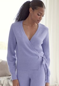 Lavender Wickelstrickpullover aus weichem Strickstoff, mit langen Ärmeln, einem tiefen V-Ausschnitt und einem Bindedetail an der Taille.