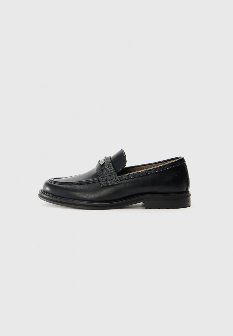 Black leather loafers with a smooth finish, featuring a textured upper band, low heel, and minimal stitching details.