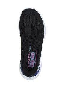 Zapatilla negra sin cordones con parte superior de punto texturizado y suela blanca. Presenta acentos florales coloridos en el talón y una plantilla acolchada con marca.