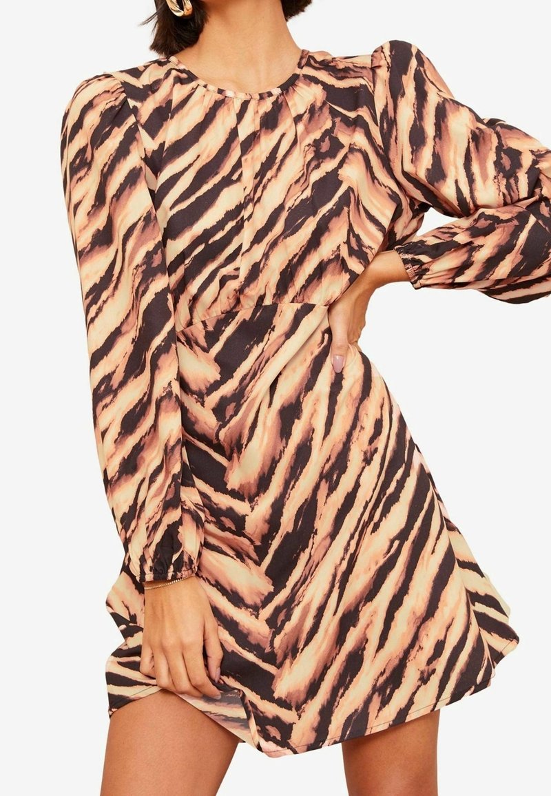 Robe à manches courtes en tissu léger présentant un motif rayures de tigre noir et pêche, avec un col rond et des poignets élastiqués.