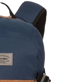 Un sac à dos en tissu bleu avec des accents marron, de forme rectangulaire, des bretelles noires ajustables, une surface texturée et une étiquette de marque sur le devant.