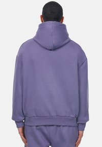 Lila Pullover-Hoodie mit einer großen, verstellbaren Kapuze. Verfügt über einen lässigen Schnitt, gerippte Ärmelabschlüsse und einen Bund, hergestellt aus weichem Baumwollmaterial.