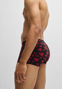Bóxers negros con estampado de corazones rojos, con una cinturilla con logo. Fabricados en un material ligero y elástico para mayor comodidad.