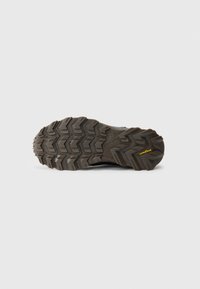 Semelle crantée d'une chaussure de plein air sombre avec de profondes rainures, arborant les logos Skechers et Goodyear sur la semelle en caoutchouc.