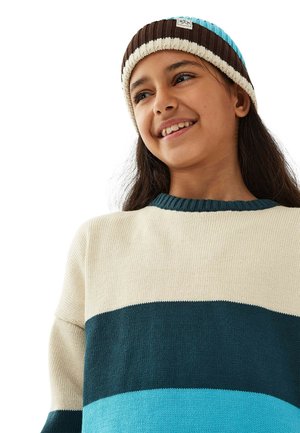 Kerman, teal, ja tummanvihreä raidallinen neulepaita, jossa on ribbauskaulus, yhdistettynä ruskeaan ja siniseen raidalliseen neulottuun hattuun, jossa on logopatch.
