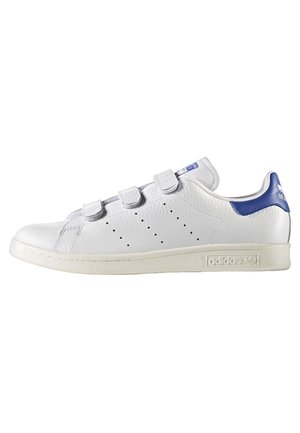 Biały niski sneaker Adidas z paskami na rzep, perforowanymi bocznymi paskami i niebieskim detalem na języku pięty.