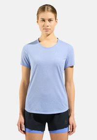 T-shirt de sport bleu clair à manches courtes avec un col rond et une texture subtile, associé à un short de sport noir avec des accents bleus.