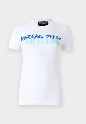 White short-sleeve t-shirt featuring blue and turquoise text "VERSACE JEANS COUTURE" in varying fonts and sizes across the front.