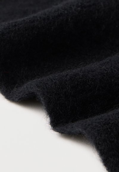 Tela de lana negra con una superficie suave y texturizada, que presenta un aspecto ligeramente difuso y un suave caída.