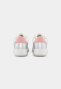 Silver leather sneakers with pink heel accents, white soles, and a smooth texture. Features logo on the back. Closed design.