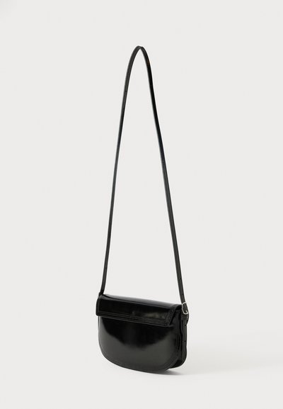 Black leather crossbody bag with a smooth texture, curved shape, and a thin adjustable strap. Features a flap closure and minimal stitching.