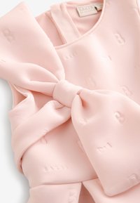 Abito senza maniche di un rosa chiaro con un dettaglio a fiocco in vita. Realizzato in tessuto liscio con lettere in rilievo "B" e "BAKER" su tutta la superficie.