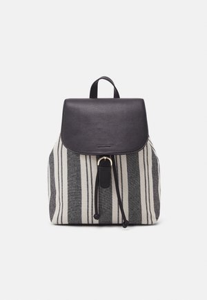 Sac à dos en tissu rayé gris et crème avec un rabat en cuir noir. Il dispose d'une fermeture à cordon et d'un accent métallique.