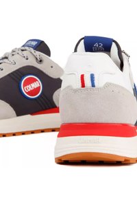 Par Colmar sneakers, den ene viser bagsiden med grå ruskind og rød stribe, den anden viser siden med navyblå og Colmar-logo.