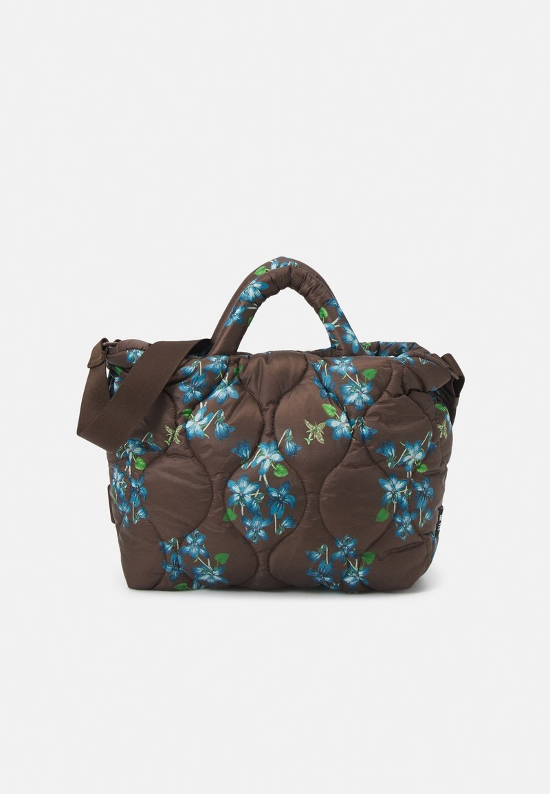 Brun vadderad tygväska med blå och gröna blommönster, dubbla handtag och ett avtagbart axelband. Mjuk, vadderad textur.