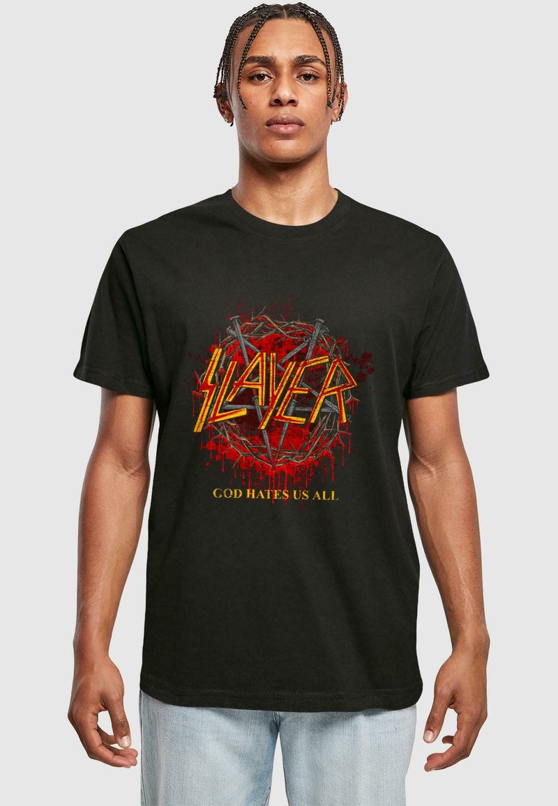 Black cotton t-shirt featuring a large graphic with the word "SLAYER" in yellow, surrounded by red drips and a pentagram design, text below reads "GOD HATES US ALL."