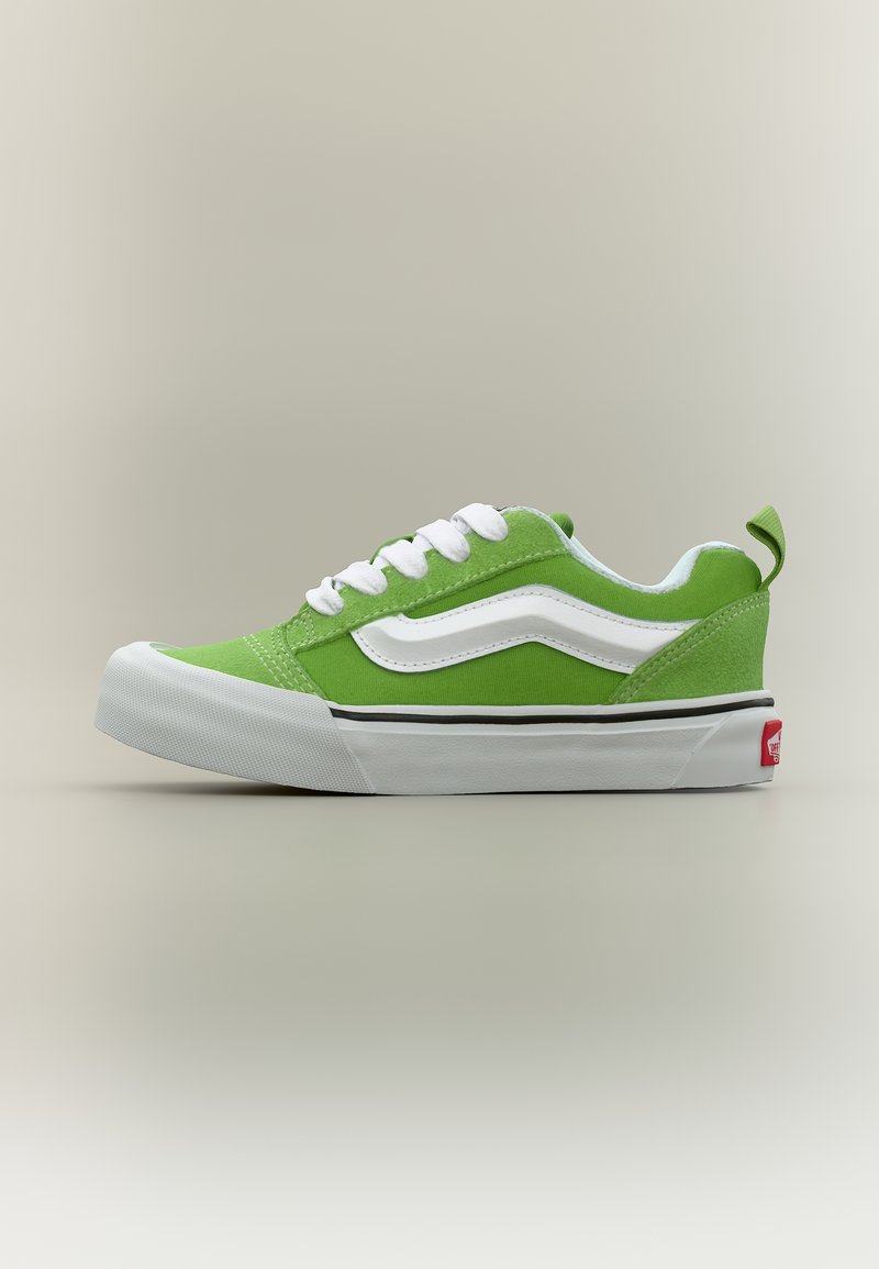 Πράσινο και λευκό sneaker χαμηλού προφίλ με λευκά κορδόνια, λευκό κυματιστό σχέδιο στο πλευρό και χοντρή λευκή λαστιχένια σόλα.