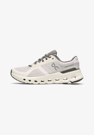 Baskets de sport blanches et grises avec un dessus en maille respirante, semelle rembourrée avec des découpes et un marquage subtil sur le côté.