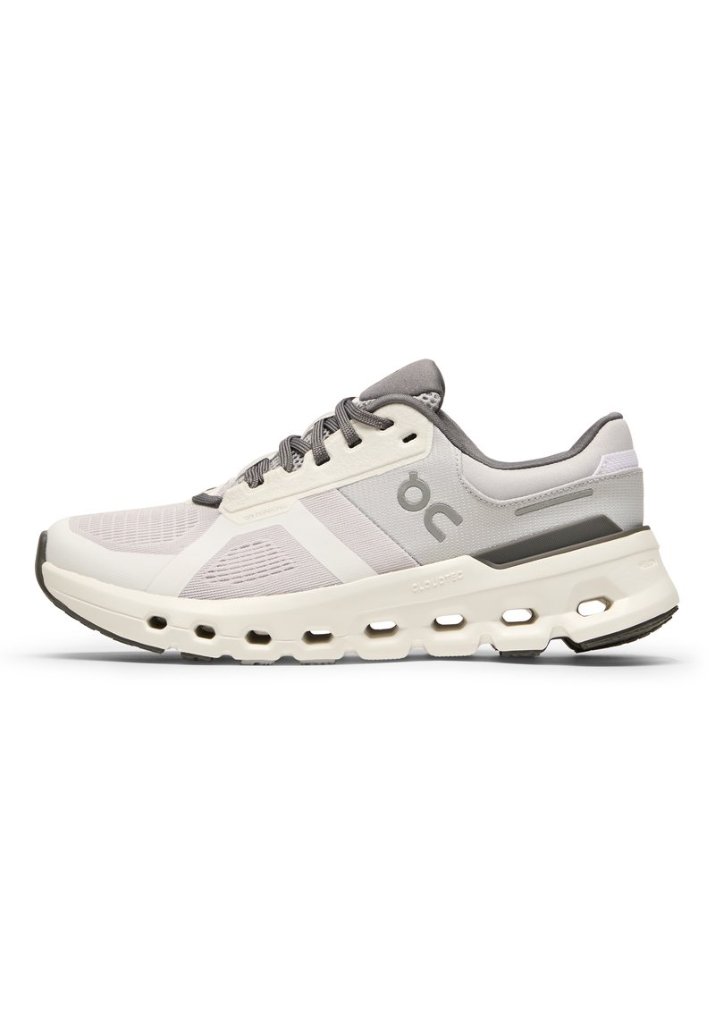 Scarpa sportiva bianca e grigia con tomaia in rete traspirante, suola ammortizzata con ritagli e un marchio discreto sul lato.
