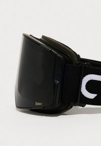 Gafas de esquí negras con una lente grande y curvada, forro de espuma suave y una correa negra ajustable con letras blancas.