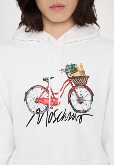 White hoodie with a red bicycle graphic, featuring a basket of greens and baguettes, and "Moschino" in black cursive below.