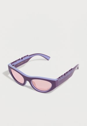 Μοβ γυαλιά ηλίου με σχήμα cat-eye και ροζ φακούς, με το εμπορικό σήμα «Dolce & Gabbana» στα πλευρά, παρουσιασμένα σε λευκό φόντο.