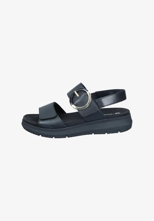 Schwarze Sandale mit flacher Sohle, einem breiten Riemen mit einem runden Metallakzent und einem verstellbaren Riemen hinten für zusätzlichen Halt. Glatte Textur.