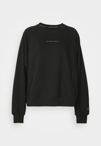 Sweat-shirt noir à manches longues et col rond avec le texte "Jordan Sport" sur la poitrine et un petit logo Jumpman sur le poignet gauche.