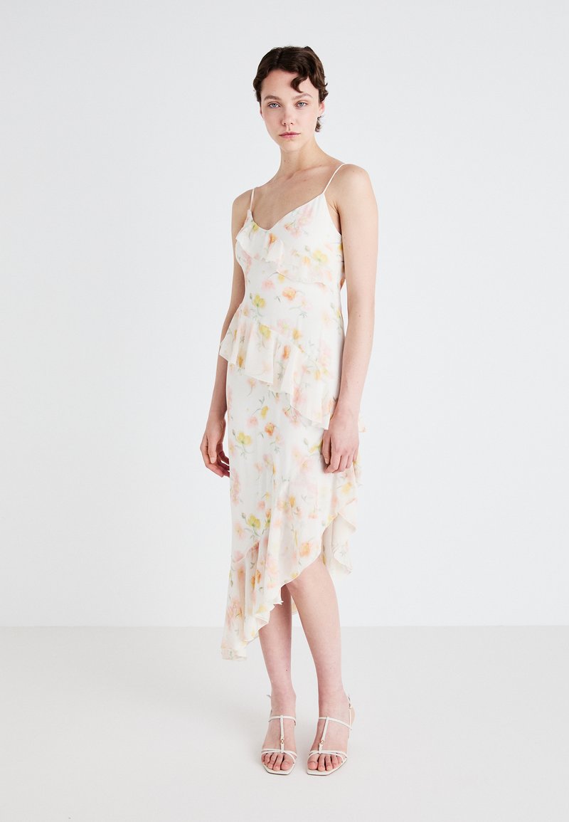 Blomstertrykt kjole med peplum-design, med volang-lag, justerbare spaghetti-stropper og asymmetrisk kant i myke pastellfarger.