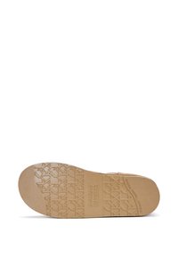 Semelle de chaussure en caoutchouc brun avec un motif texturé. Comprend des logos en relief et une combinaison de zones planes et striées pour une meilleure adhérence.