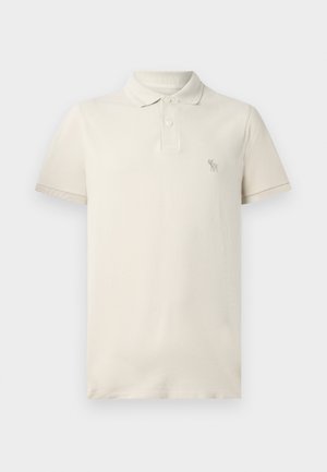 Beige polo shirt made from cotton, featuring a collar, short sleeves, and a small embroidered logo on the chest. Soft texture with a classic fit.