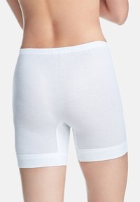 Weiße Baumwollboxershorts haben eine glatte Textur, einen elastischen Bund und eine Länge bis zur Mitte des Oberschenkels mit einem minimalistischen Design und ohne sichtbare Muster.