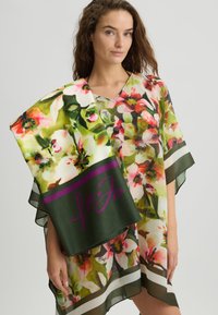 Floral print poncho in lightweight fabric, featuring vibrant colors and a v-neck design. Includes a matching scarf with a dark green band.