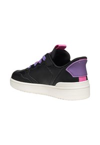 Zapatilla de cuero negro con cordones y detalles morados, suela blanca y una pestaña en el talón morada. Presenta una textura suave y una forma redondeada.
