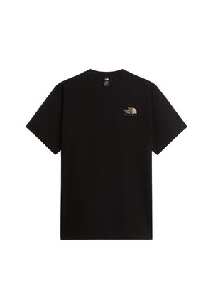 Hombre con gorra negra The North Face y camiseta negra con logo en el pecho, combinada con pantalones cargo oliva, de pie sobre fondo blanco.
