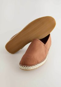 Brune slip-on sko lavet af tekstureret stof med en rund tå. Har en vævet jute mellemsål og en gummisål med fiskebensmønster.