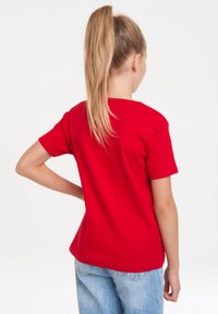 Red cotton t-shirt with short sleeves and a straight cut. The back features a round neckline and a smooth, unembellished surface.