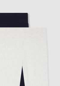 Jasnoszare legginsy w granatowym kolorze z zawijaną talią. Materiał wydaje się miękki o subtelnej fakturze i ma rozcięcie na końcu nogawki.