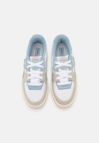 Sneakers med en vit textilöverdel, blå accenter, beige mockadetaljer och snören. Har en vadderad plös och en gummisula.