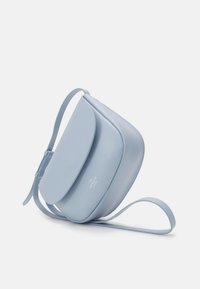 Světle modrá kožená kabelka přes rameno s zakřivenou klopou, nastavitelným popruhem a minimalistickým designem. Hladká textura a jemný detail loga.