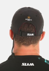 Cappello nero con un logo a stella dorata e la scritta "ESTRELLA DAMM" ricamata sul retro. Presenta una chiusura regolabile con il marchio "SLAM".