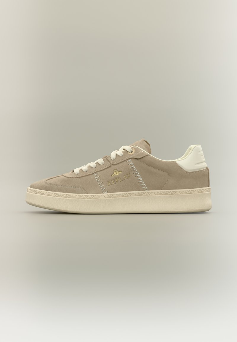 Beige Wildleder-Sneaker mit weißen Schnürsenkeln und Ferse, mit goldfarbenem Logo und Steppdetails sowie einer strukturierten Gummisohle.