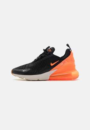 Sneaker athlétique noir avec des accents orange. Comprend un dessus en maille, une semelle rembourrée, une semelle en caoutchouc et une unité Air proéminente dans le talon.