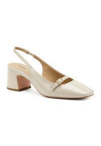 Tacco slingback in pelle beige con punta quadrata, cinturino regolabile e tacco a blocco medio, caratterizzato da un accento rosa contrastante alla base.