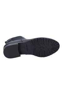 Black boot with textured mesh panel, rounded toe, and rubber sole featuring a patterned tread. Brand name engraved on the sole. Size 37.