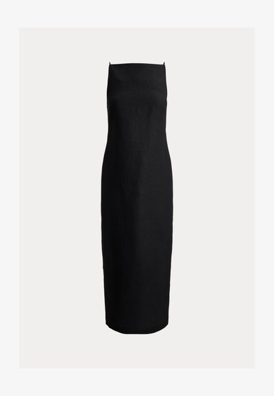 Μακρύ, μαύρο, εφαρμοστό φόρεμα χωρίς τιράντες, με ίσιη γραμμή στο ντεκολτέ και τελείωμα μέχρι τους αστραγάλους, σε απλό φόντο.